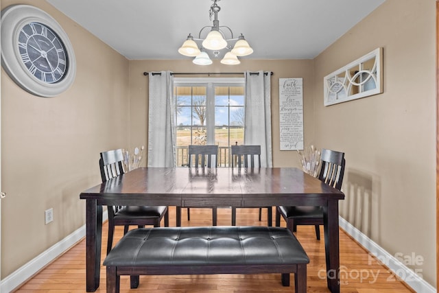 dining space featuring hardwood / wood-style floors and a chandelier