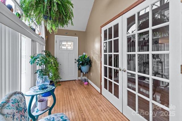 interior space featuring hardwood / wood-style flooring, vaulted ceiling, and french doors