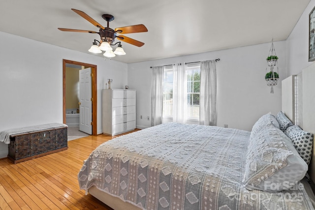 bedroom with ceiling fan, wood-type flooring, and connected bathroom