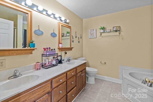 bathroom with vanity, a tub to relax in, and toilet