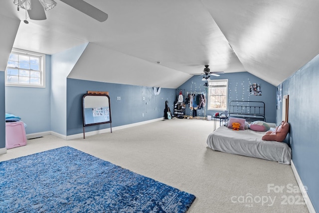 carpeted bedroom with multiple windows, vaulted ceiling, and ceiling fan