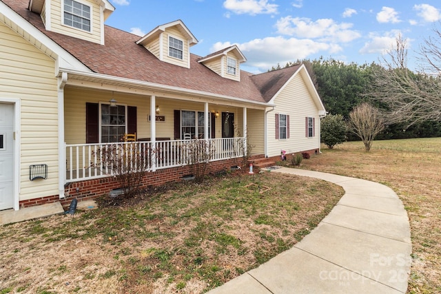 new england style home featuring a porch and a front lawn