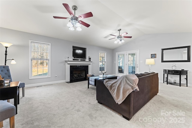 carpeted living room featuring vaulted ceiling, ceiling fan, and a fireplace