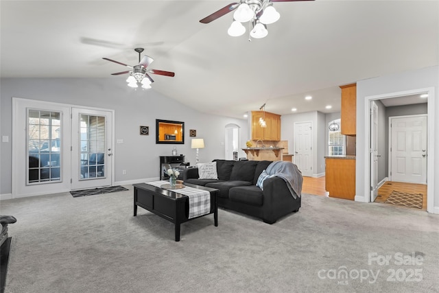 carpeted living room with ceiling fan and lofted ceiling