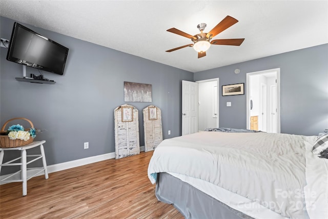 bedroom featuring hardwood / wood-style flooring, ceiling fan, and connected bathroom