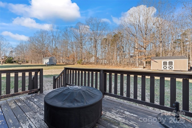 deck featuring a grill, a yard, and a shed