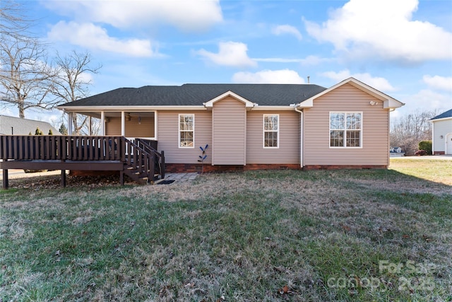 rear view of property featuring a yard and a deck