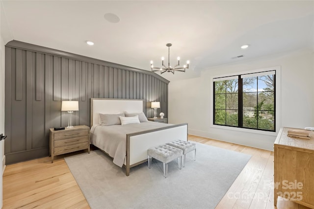 bedroom with light wood finished floors, recessed lighting, visible vents, and a notable chandelier