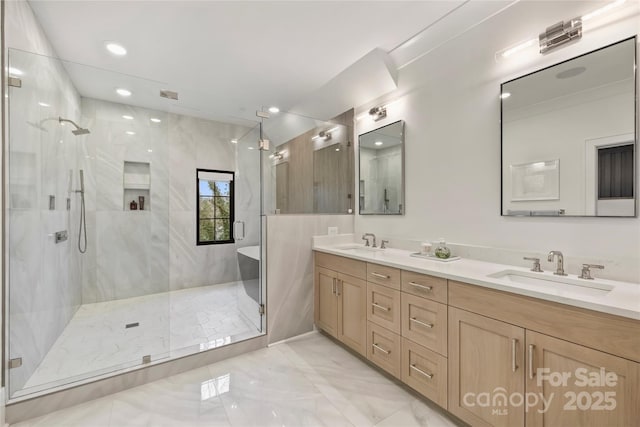 full bathroom with a sink, a marble finish shower, and double vanity