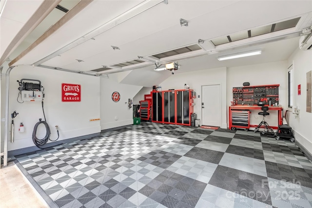 garage with baseboards, a workshop area, and a garage door opener