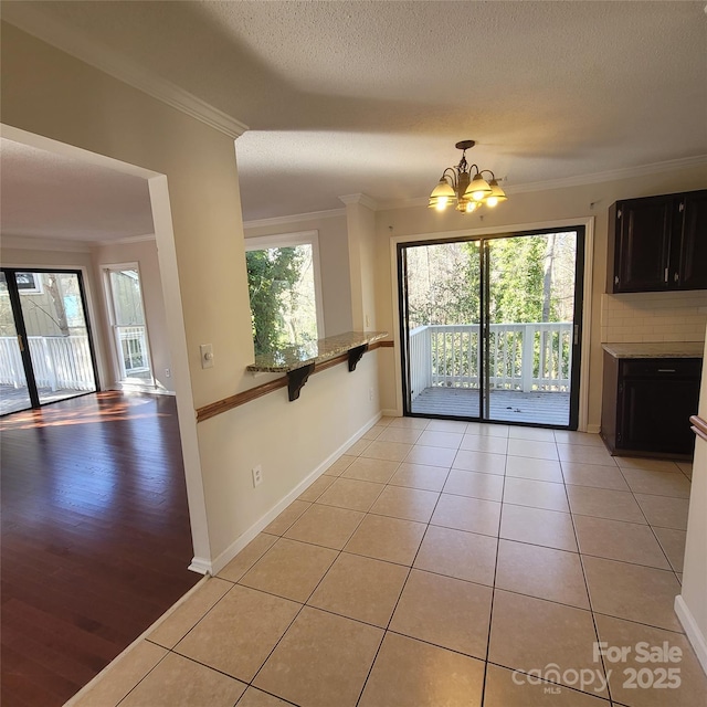 interior space with crown molding, a healthy amount of sunlight, and light tile patterned floors