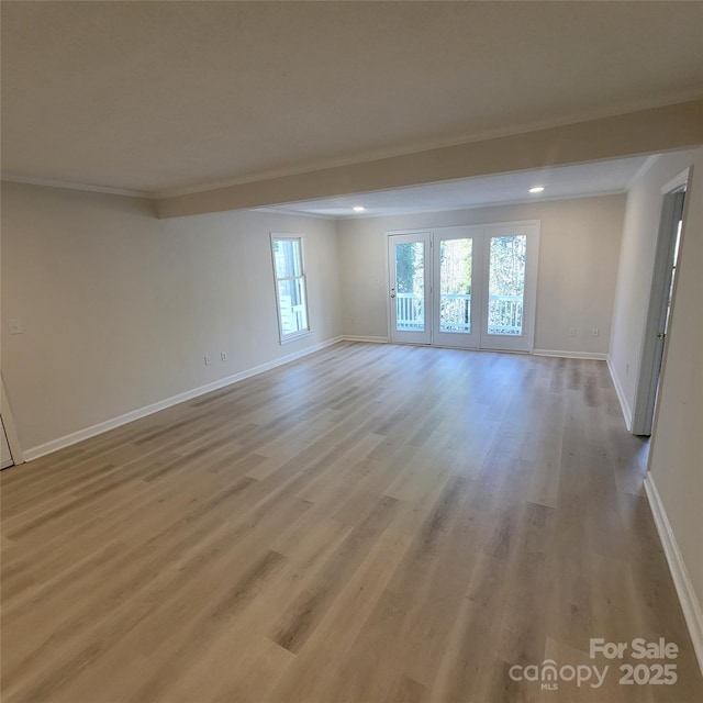 spare room with ornamental molding and light hardwood / wood-style flooring