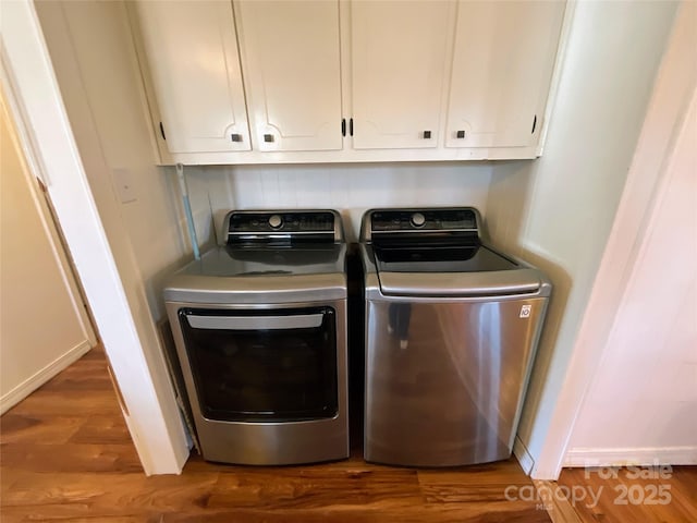 laundry room featuring independent washer and dryer, wood finished floors, and cabinet space