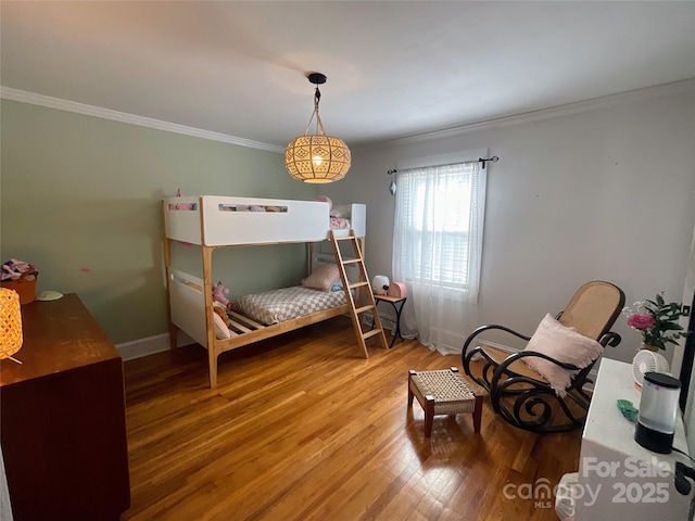 bedroom with baseboards, wood finished floors, and crown molding