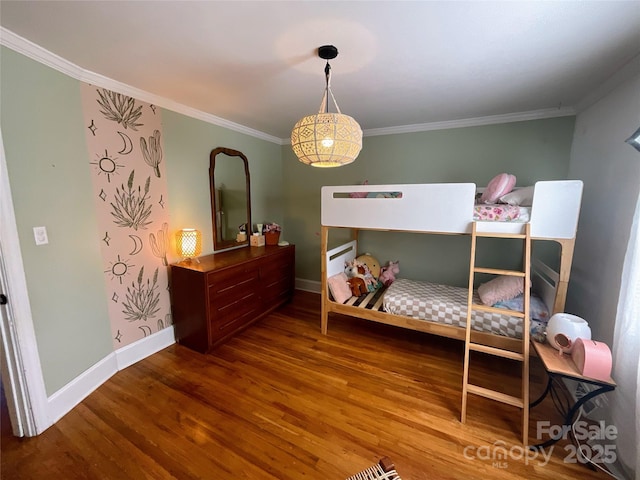 bedroom with ornamental molding, baseboards, and wood finished floors