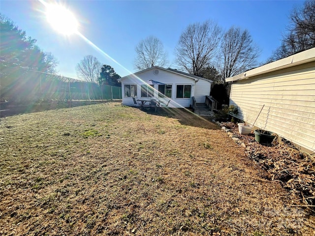 back of house with a yard and fence