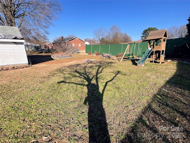 view of yard featuring fence and a playground