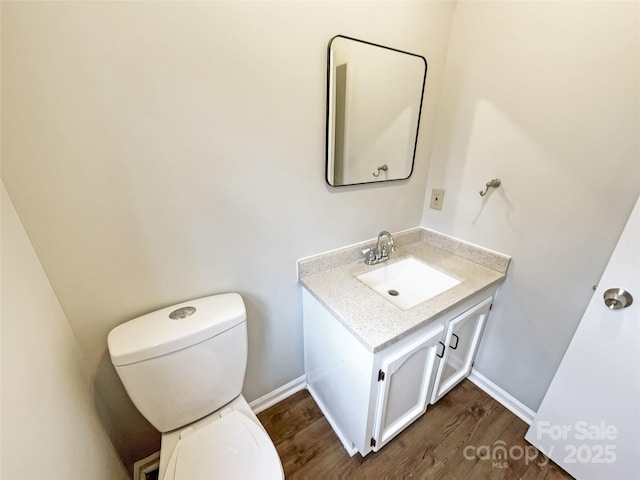 bathroom with vanity, toilet, and wood-type flooring