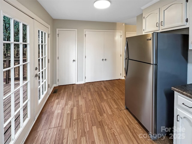 kitchen featuring white cabinetry, stainless steel fridge, light hardwood / wood-style floors, and french doors