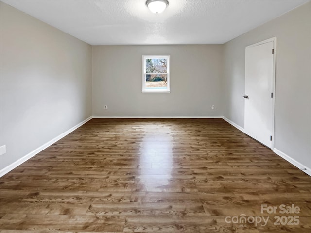 empty room featuring dark hardwood / wood-style flooring and a textured ceiling