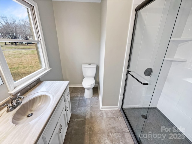 bathroom with a shower with door, vanity, and toilet