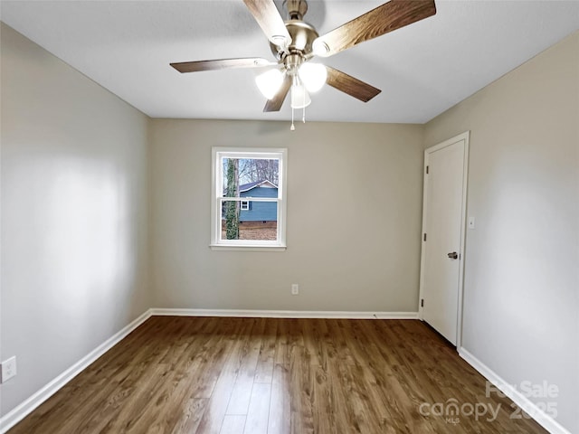 spare room with dark wood-type flooring and ceiling fan