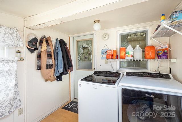 laundry room with washing machine and dryer and light wood-type flooring