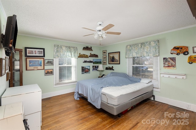 bedroom featuring hardwood / wood-style flooring, ornamental molding, and a textured ceiling