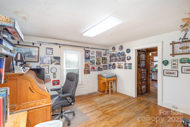 home office with hardwood / wood-style flooring and a textured ceiling