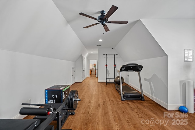 exercise room featuring ceiling fan, vaulted ceiling, and light hardwood / wood-style flooring