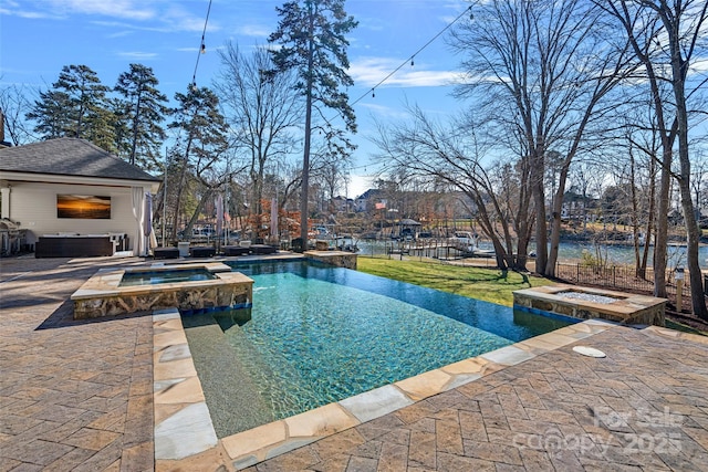 view of pool featuring a patio area and an in ground hot tub