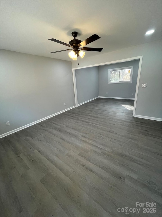 empty room with ceiling fan and dark hardwood / wood-style floors