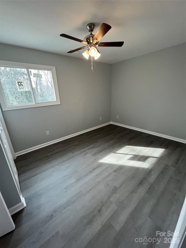 empty room with ceiling fan and dark hardwood / wood-style flooring