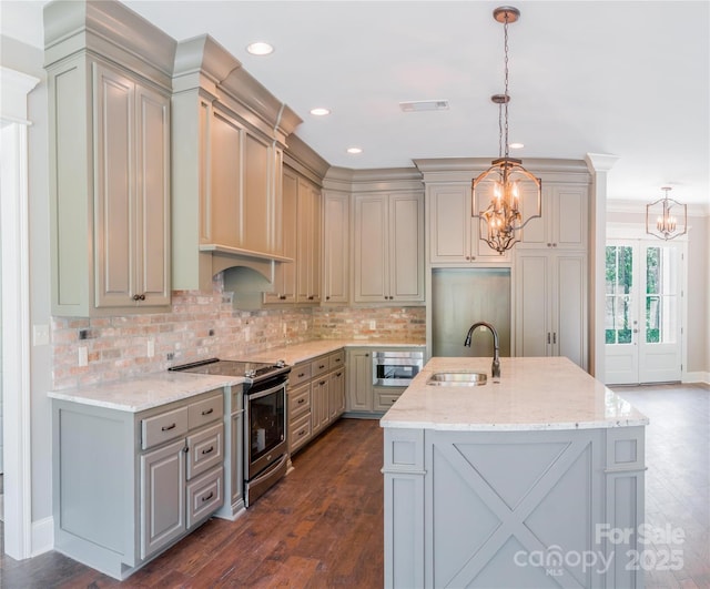 kitchen with sink, gray cabinets, hanging light fixtures, electric range, and a center island with sink