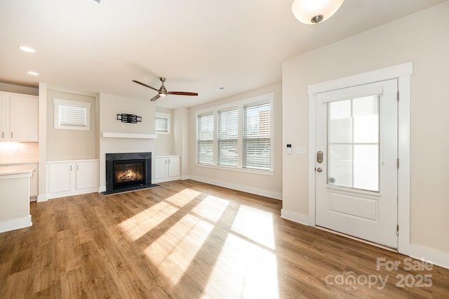 unfurnished living room with light hardwood / wood-style flooring and ceiling fan