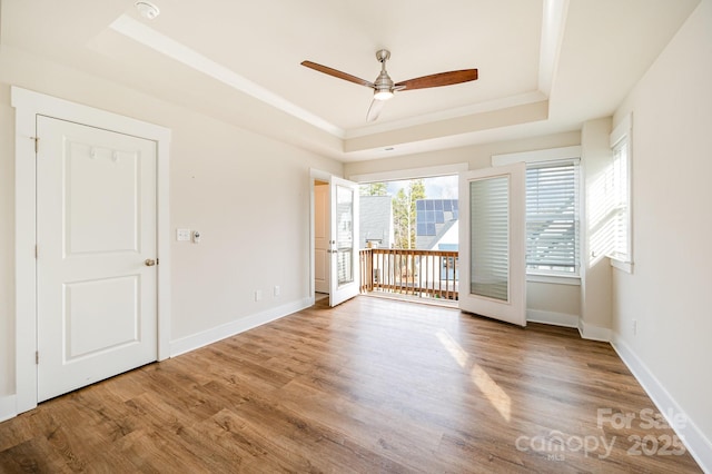 unfurnished room featuring crown molding, a tray ceiling, ceiling fan, and hardwood / wood-style flooring