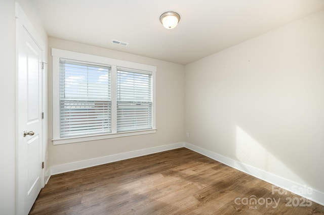 spare room with wood-type flooring