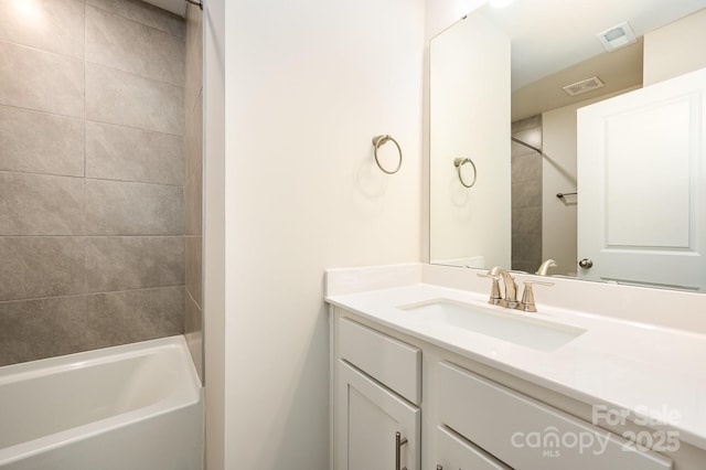 bathroom with vanity and tiled shower / bath combo