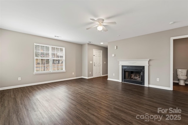 unfurnished living room featuring ceiling fan and dark hardwood / wood-style flooring