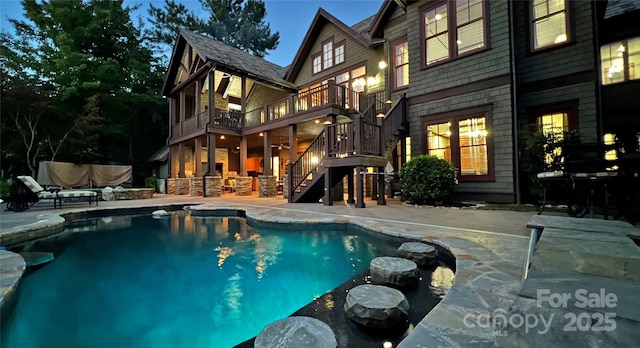 outdoor pool with a patio area and stairs