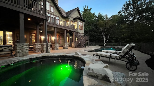 outdoor pool with stairway, a patio area, and a jacuzzi