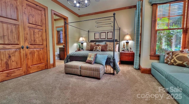 carpeted bedroom featuring ornamental molding, ensuite bathroom, baseboards, and an inviting chandelier