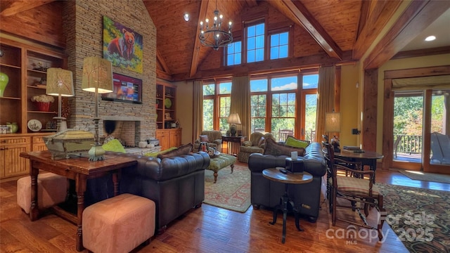 living area featuring a chandelier, high vaulted ceiling, a stone fireplace, hardwood / wood-style flooring, and beam ceiling