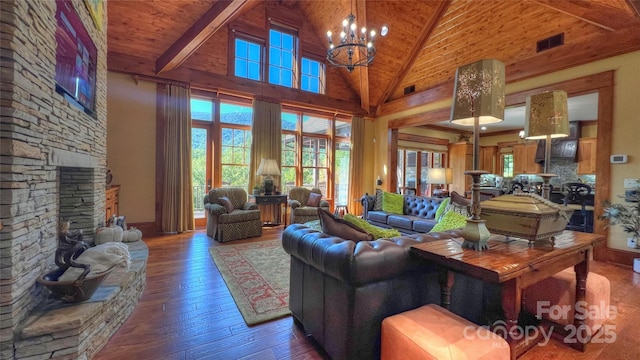 living room featuring visible vents, wooden ceiling, hardwood / wood-style floors, a stone fireplace, and a chandelier