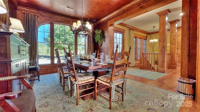 dining space featuring an inviting chandelier, crown molding, visible vents, and wood finished floors