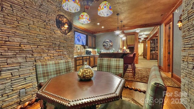 dining space with ornamental molding and light wood-type flooring