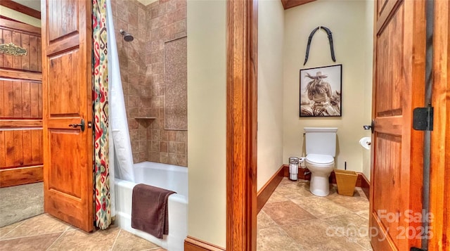 full bathroom featuring shower / bath combination with curtain, baseboards, and toilet