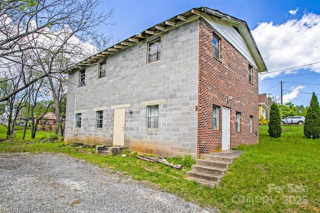 view of side of home with a yard