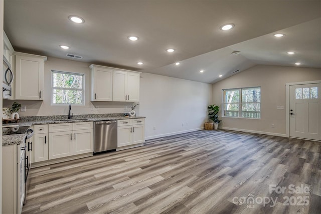 kitchen with sink, light stone countertops, white cabinets, and appliances with stainless steel finishes