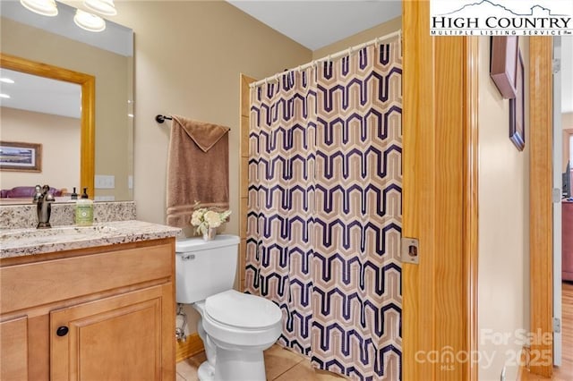 bathroom with vanity, toilet, curtained shower, and tile patterned flooring